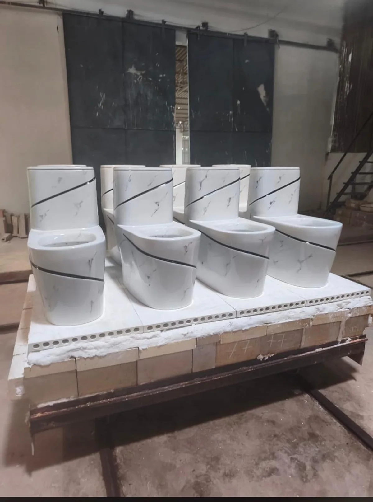 White marble-finish one-piece toilets on a kiln car